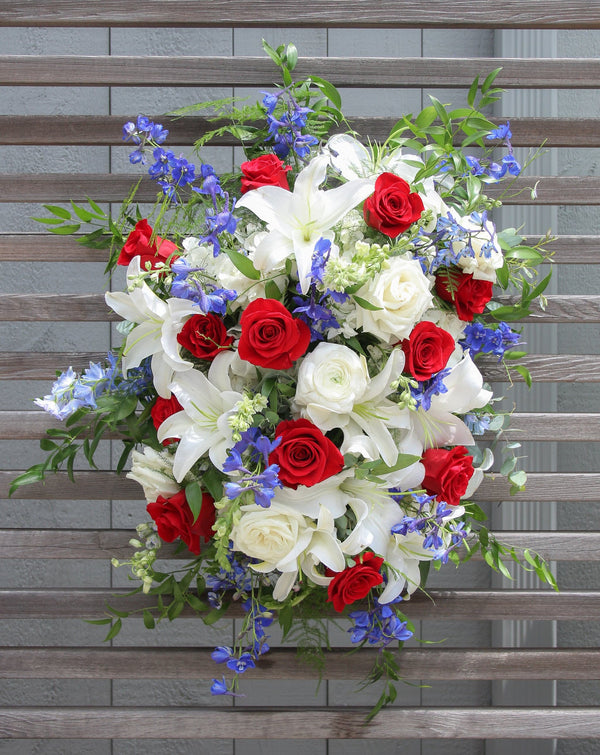 A funeral spray with red, white and blue flowers.