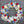 Load image into Gallery viewer, A round funeral wreath with red, white and blue flowers.