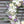 Load image into Gallery viewer, A round funeral wreath with white and pale purple flowers.