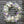 Load image into Gallery viewer, A round funeral wreath with white and pale purple flowers.