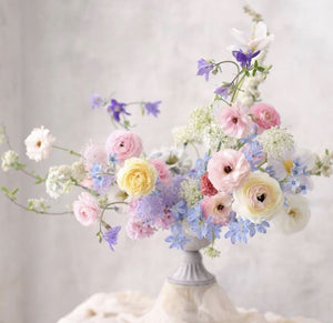 A photo of a Flowering Arranging Class. A flower arrangement in pale colors.