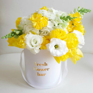 A photo of a yellow and white flower arrangement.