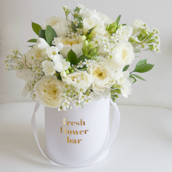 A photo of a pale yellow and white flower arrangement.