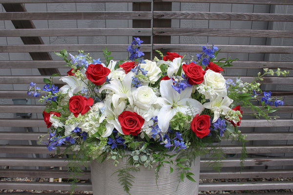 A photo of a Full Casket Cover with red, white and blue flowers for a Veteran or Military Person.