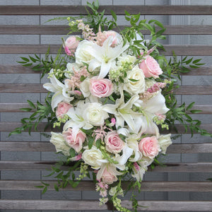 A funeral spray with white and pale pink flowers.